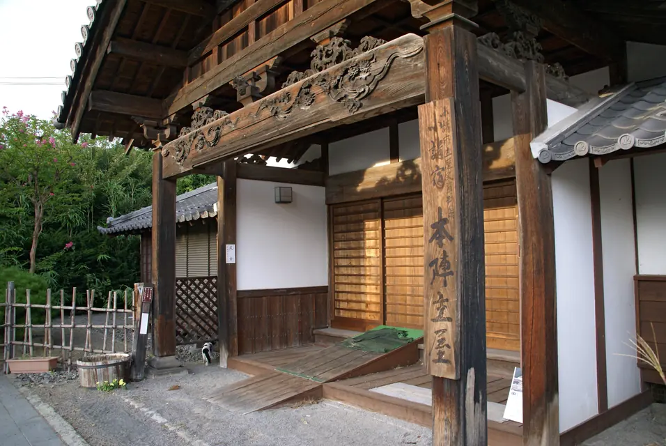 日本の住宅の玄関前に高さを変えて配置した花の鉢植え
