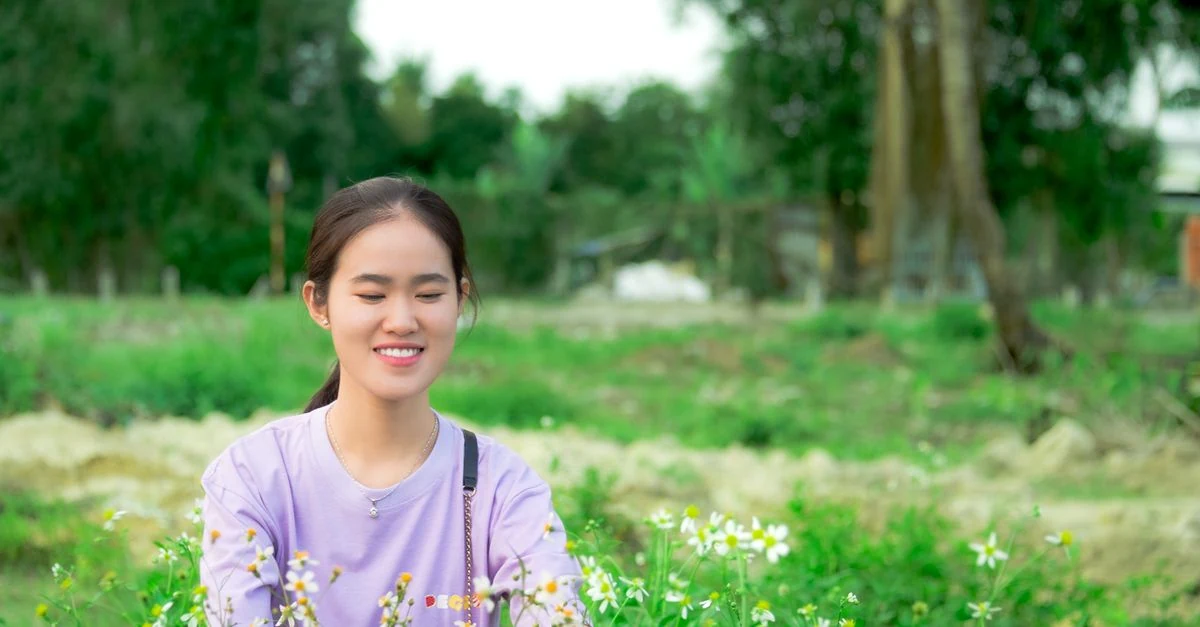 明るい室内のテーブルに季節の花を一輪ずつ生けた花瓶