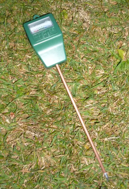 花鉢へ挿した土壌水分センサーと測定履歴を表示するスマートフォン